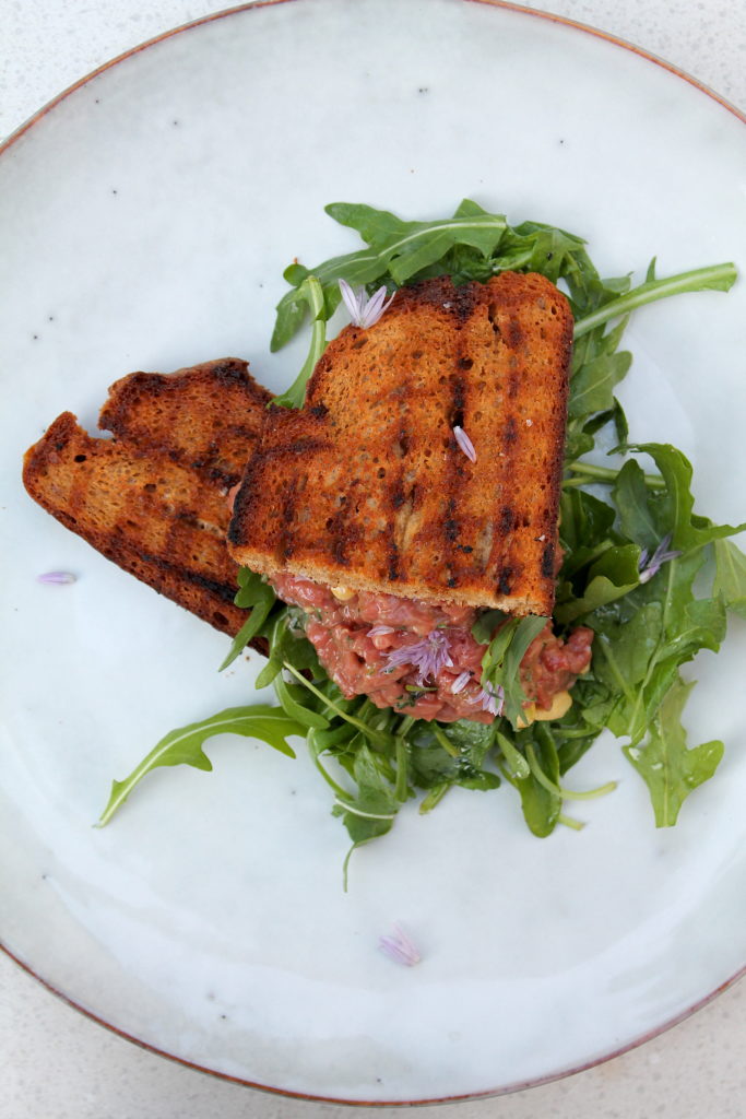 Tatar vom Rehrücken, Estragon und Pinienkernen - serviert mit Röstbrot und Rucola
